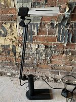 Full side view of vintage Italian Memphis style desk lamp showing black metal adjustable arm, base, and white rectangular lampshade.