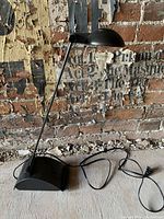 Full view of vintage Italian Memphis style desk lamp, black metal with extendable arm and dome shade.