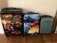 Full view of all three hard case suitcases arranged side by side showing different sizes and designs.