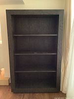Front view of the large solid wood bookcase with three fixed shelves.