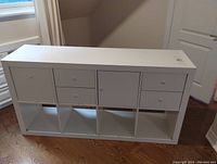 Front view of white IKEA storage cabinet with 6 drawers and 6 open cubby shelves on bottom, showing overall structure and storage layout.