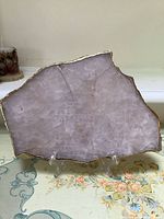 Front view of the pink quartz geode slice showing pink crystalline texture and gold border on clear acrylic stand.