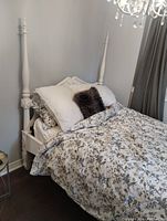 Front angle showing carved headboard, finials and bedding