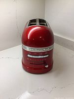 Full front view of red KitchenAid toaster showing two slots and controls.