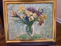 Frontal view of the signed oil painting of floral art in a gilded frame.