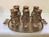 Front view of set showing six fish design shot glasses placed on the oval tray with fish-shaped handles.