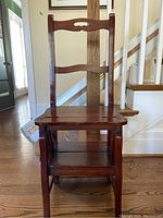 Front view of antique wooden metamorphic chair showing the seat and backrest with classic slat design.