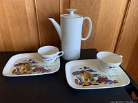Two breakfast sets with coffee cups and plates showing the fishing design, and the white Thomas Germany coffee pot.