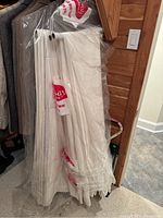 Duvet and curtain panels packaged in clear dry cleaning bags hung vertically with hangers