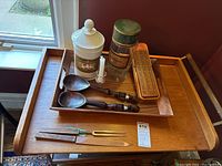 Wood trays with salad servers, carving set, cribbage board, canisters, and candle holder on top of larger tray