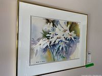 Full view of framed watercolor floral painting with gold frame and white matting