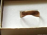 Front view of yellow gold split band ring in box