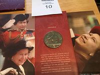 Close-up of the coin on the obverse side featuring the golden equestrian portrait with inscriptions about the coin.