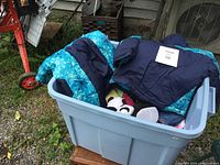 Blue container with turquoise and navy snow suit, panda slippers and assorted children's clothes for toddler, condition like new
