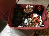 Bin filled with assorted Halloween decorations including light-up panels and cords running over the decorations.
