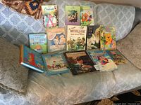 Overview photo of 13 children's books arranged on a couch, showing colorful illustrated covers of classic story titles.