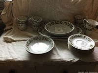 Photo showing entire dinnerware set including plates, cups, and saucers with floral patterns and gold trim.