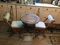 Overall view of the teak bistro set with two chairs and one round folding table