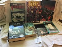 Six used books arranged on a cloth-covered surface, showing front covers with titles visible.