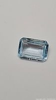 Front view of the rectangular emerald cut sky blue topaz gemstone, showing the clarity and facets.