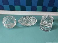 Three Waterford crystal pieces including two football-shaped engraved with Denver Broncos and Denver Nuggets logos and one round piece.