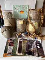 Full lot showing multiple spools of jute twine, clay pots, braided macrame hanger, vintage macrame magazines, and instructional poster.