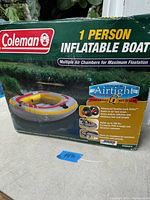 Photo of the boxed Coleman 1 person inflatable boat showing product branding, image of the boat, and features like multiple air chambers for maximum flotation.