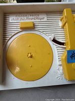 Top-down view of the yellow and white Fisher-Price Music Box Record Player showing the turntable, tonearm and embossed branding.
