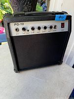 Front view of the PG-10 guitar amplifier showing control panel with input jack, multiple control knobs, speaker output, and power switch.