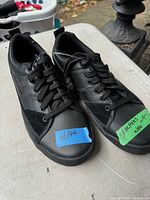 Front angle photo showing the pair of men's Skechers shoes, black with lace-up, tags visible indicating new condition and size 9.