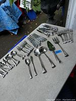 Display of all cutlery and serving pieces laid out on a table showing overall quantity and variety.