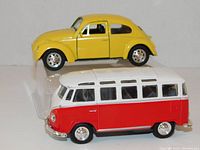 Photo showing the yellow VW Classic Beetle with doors closed and red/cream VW Microbus side view.