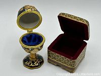 Two fabric-lined small jewellery boxes including an egg-shaped hinged box and a square hinged box.