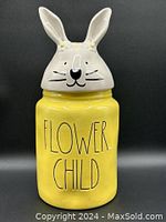Front view of yellow Rae Dunn Flower Child canister with white bunny topper and handwritten style text.