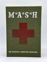 Front view of the green fabric textured box with a large red cross and M*A*S*H title.