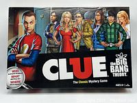 Closed game box showing The Big Bang Theory CLUE artwork featuring characters from the show and game title.