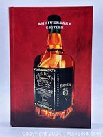 Front cover of the hardcover book showing a flaming bottle labeled 'The Dirt' and 'Anniversary Edition' text.