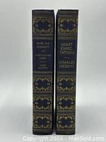 Two vintage hardcover books with dark cloth fabric covers and gold embossed decorations on the spines. One book is 'Great Expectations' by Charles Dickens, the other 'Sense and Sensibility and Northanger Abbey' by Jane Austen.
