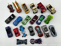 Photo of 21 assorted Hot Wheels toy cars in various colors and styles on white background