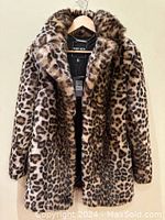 Front view of the Ever New faux leopard fur jacket hanging on a wooden hanger showing the full jacket and collar with pattern details visible.