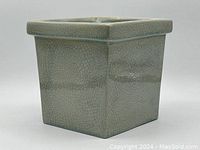Side view of square ceramic plant pot showing light blue-green crackle finish glaze on outer surface.
