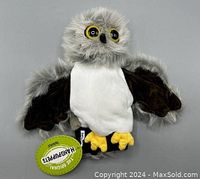 Front view of soft plush owl handpuppet showing grey fur, white belly, black wings, and yellow feet with tag.