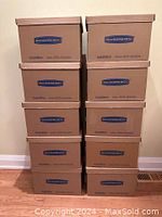 Front stacked view of ten small brown cardboard bankers boxes with lids, showing the 'BANKERS BOX SmoothMove' logo and text on the front sides.