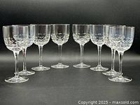 Eight crystal stemware glasses arranged side by side showing the cut crystal bowl and faceted stem design.