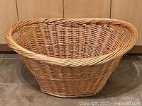 Side view of large wicker basket showcasing its shape, color, and built-in handles.