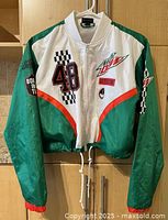 Front view of Mountain Dew womens windbreaker bomber jacket showing white center panel, green sleeves with orange stripes, black and red number 48 with checkered flag pattern, Mountain Dew logo on chest, and front zipper.
