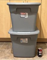 Two Sterilite gray plastic storage bins stacked with snap-on lids, next to a soda can for size comparison.