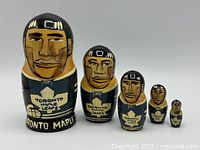 Full set of five Toronto Maple Leafs nesting dolls arranged by size from largest to smallest. Shows the facial details and handpainted Toronto Maple Leafs logos on the front.