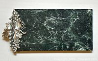 Full view of the green marble serving tray showing the rectangular shape and natural veining in the marble with pewter grape and leaf embellishment in one corner.