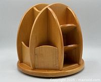 Front and side view of wood desktop organizer showing multiple vertical compartments and round spinning base.